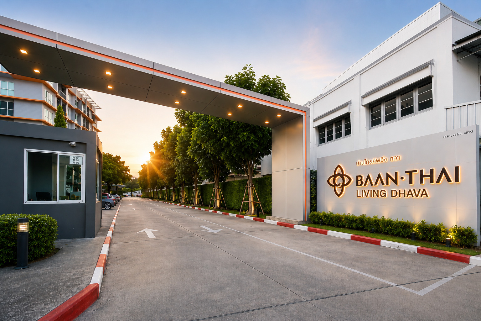 ทางเข้าโครงการขนาดใหญ่ พร้อมป้อมรักษาความปลอดภัยและบรรยากาศร่มรื่นตลอดสองข้างทาง